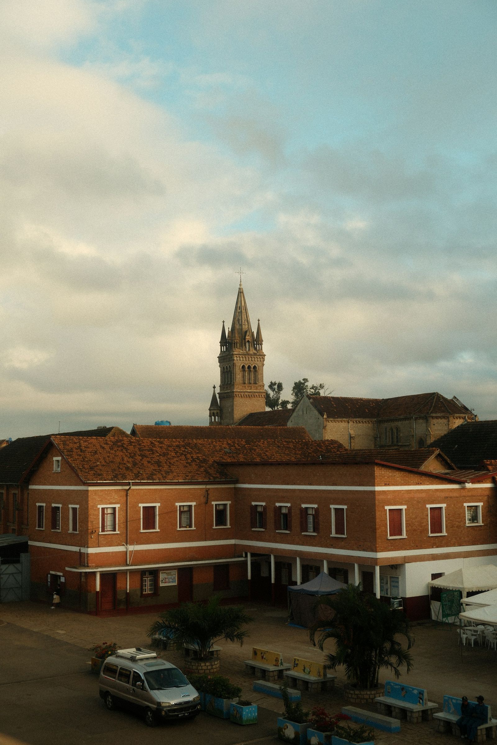Brick buildings and a church spire in Antsirabe under a cloudy sky