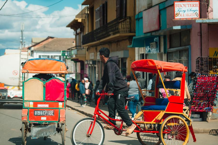 A cycle pousse-pousse, the bicycle rickshaw, on a busy street in Antsirabe