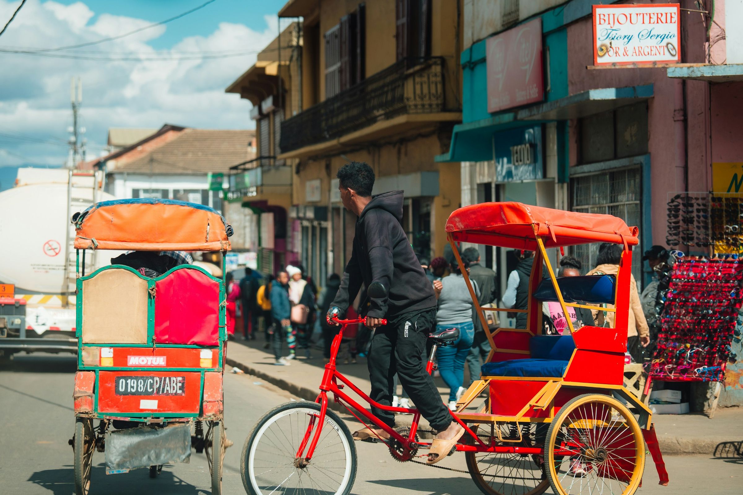 A cycle pousse-pousse, the bicycle rickshaw, on a busy street in Antsirabe