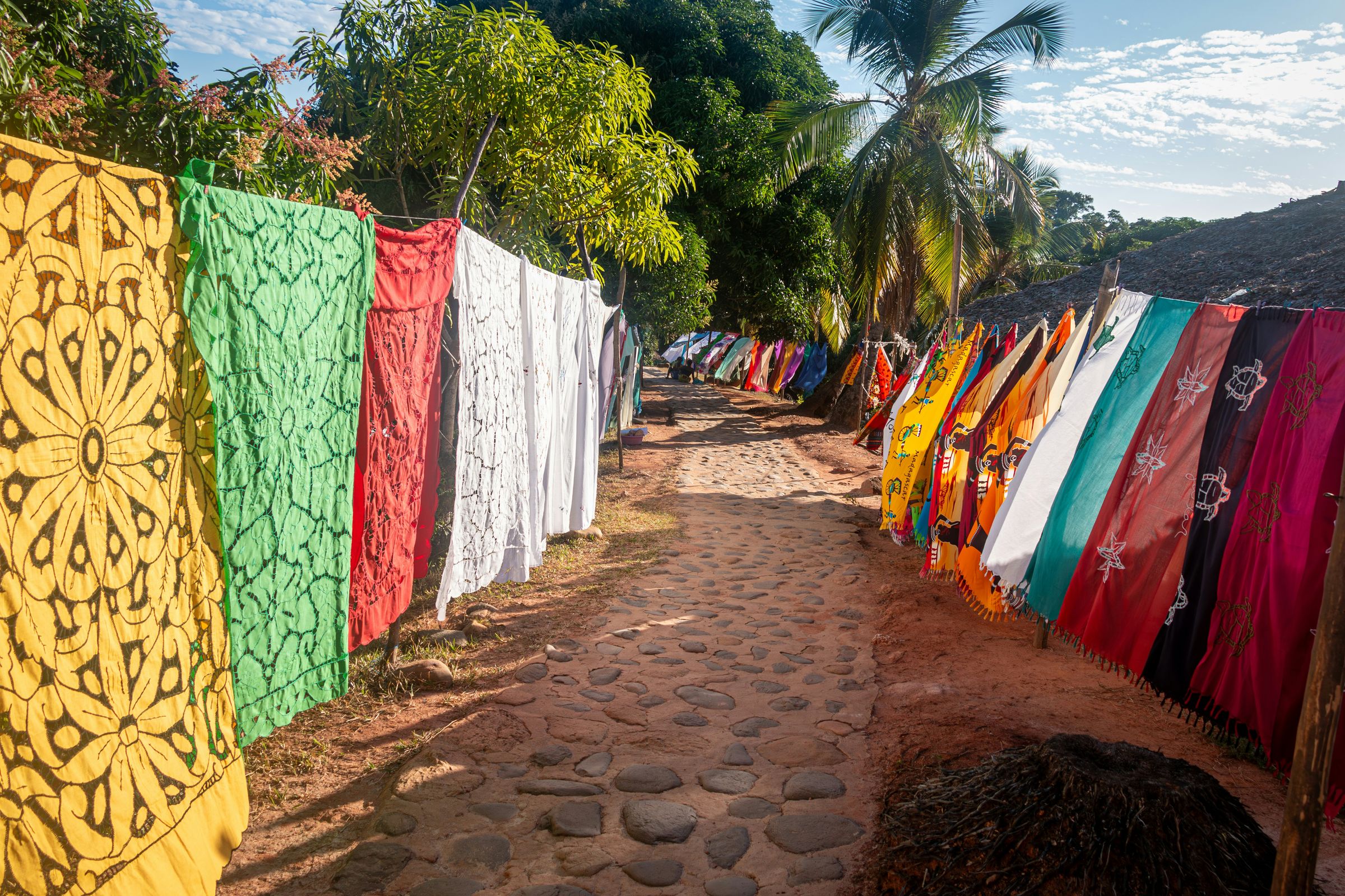 Pareos for sale hanging along a path on Nosy Iranja