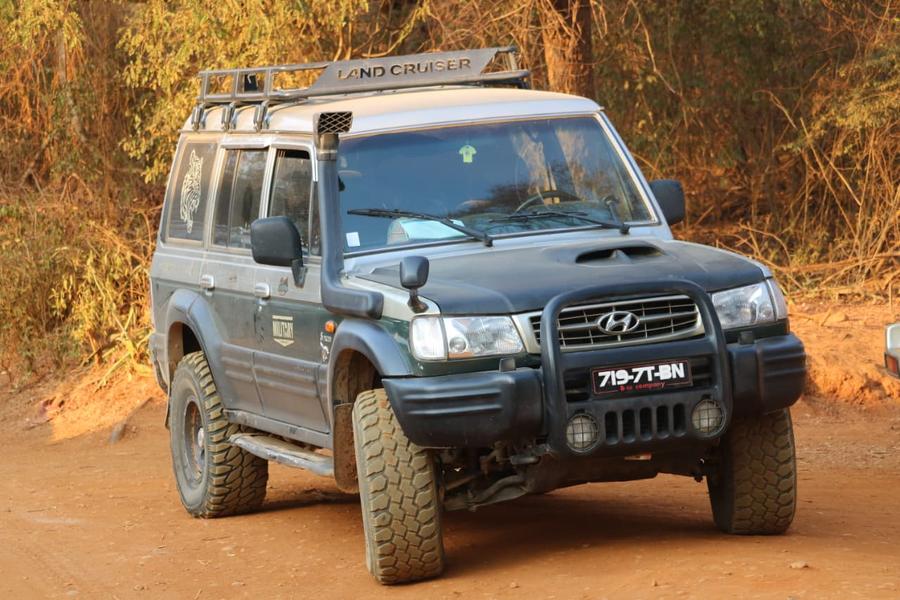 Our 4x4, with its roof rack and snorkel, on a red dirt track in Madagascar