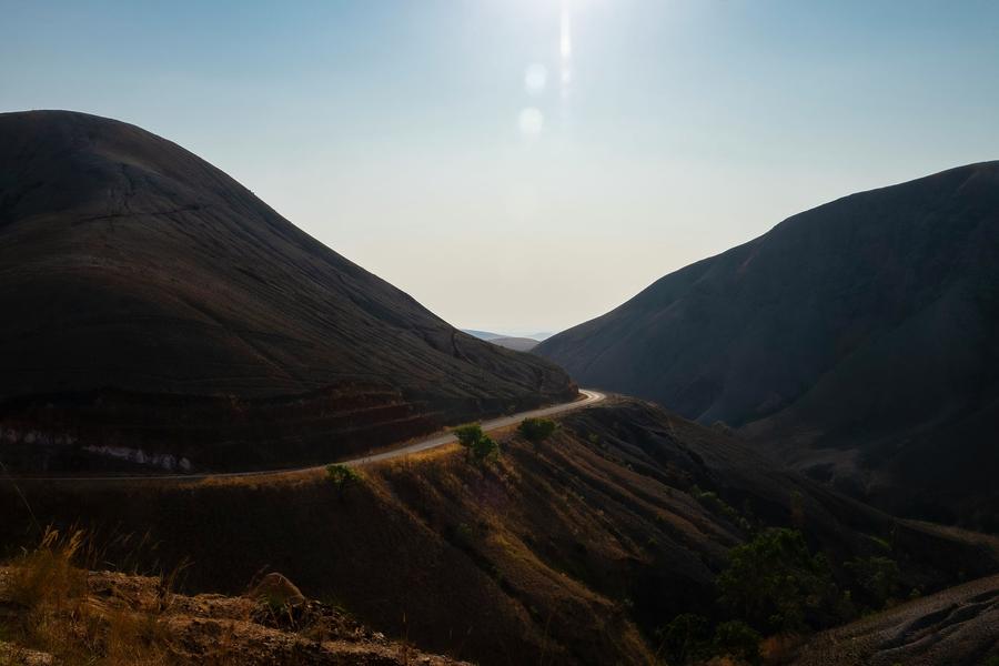 A road curving through bare highland hills on the way south
