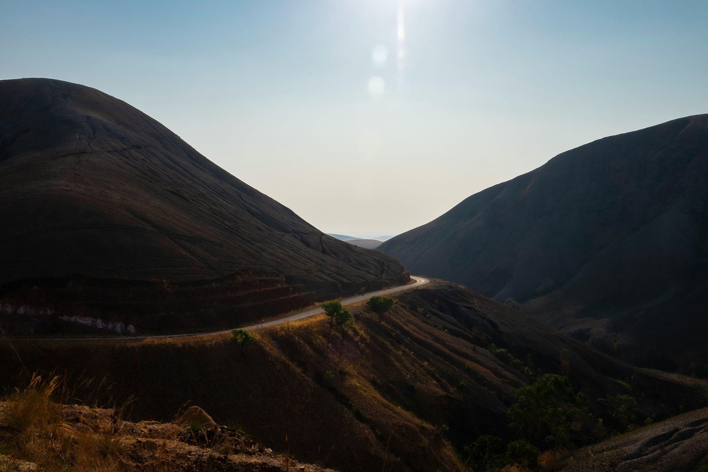 A road curving through bare highland hills on the way south