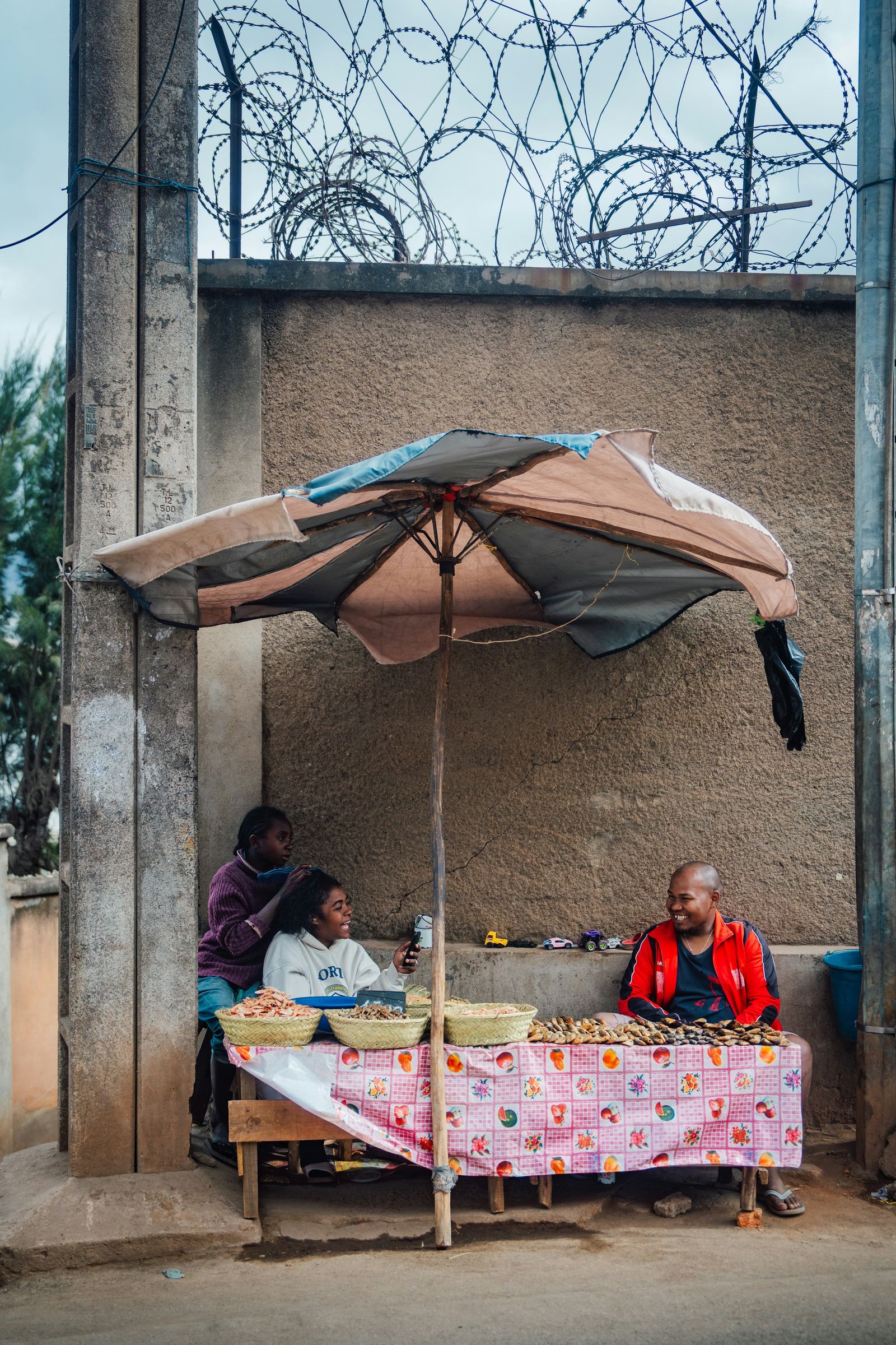 Sellers with baskets of dried fish and shrimp at a street stall in Antananarivo